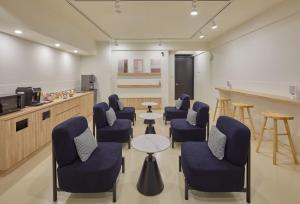 a waiting room with blue chairs and a table at Stay Easy lnn in Tainan