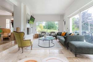 un soggiorno con un divano e un tavolo di Amazing Villa with Swimming Pool a Englesqueville-en-Auge