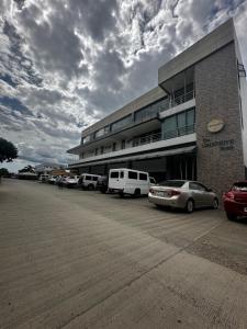 a parking lot with cars parked in front of a building at The Greenhive Hotel in Ibaan +22 photos