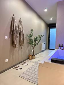 a bathroom with a blue tub and a potted plant at L'Écrin Bohème - Jacuzzi & Sauna - Amiens in Amiens +5 photos