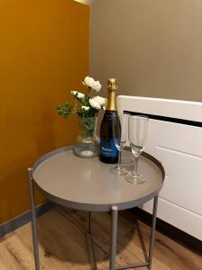 a table with a bottle of champagne and two glasses at L'Écrin Bohème - Jacuzzi & Sauna - Amiens in Amiens