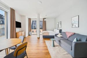 a living room with a couch and a bed at Limehome Chemnitz Kirchgässchen in Chemnitz