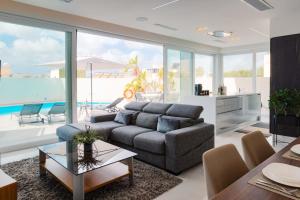 a living room with a couch and a table at Villa Ixoria with Private Pools by ArcoCollection in St. Julianʼs