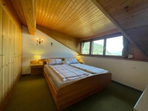 a bedroom with a large bed with a wooden ceiling at Apartment Bergmelodie in Coldrano