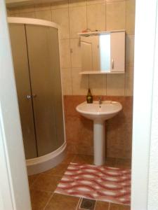 La salle de bains est pourvue d'un lavabo et d'une douche. dans l'établissement Apartman Strezoski, à Ohrid