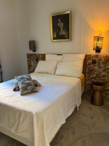 een slaapkamer met een groot bed met witte lakens en kussens bij Appartement chic et de caractère ! in Saint-Cyr-au-Mont-dʼOr