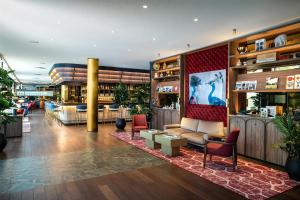 a lobby of a bar with a couch and chairs at Radisson Blu Media Harbour Hotel, Düsseldorf in Düsseldorf +59 photos