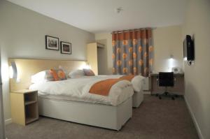 a bedroom with a bed and a desk and a television at Royal George Hotel in Birmingham