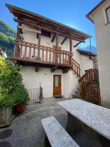 a building with a wooden balcony and a bench at Casa Arcuri in Giumaglio