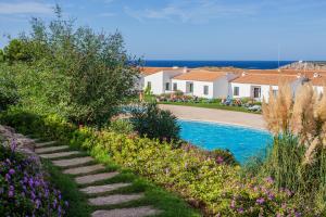 un jardín con piscina y flores en Apartamento en Arenal en Castell, en Arenal d'en Castell
