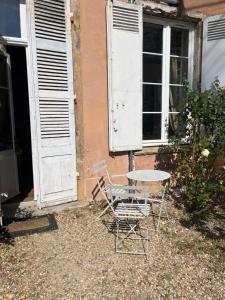 een tafel en stoelen buiten een huis bij Appartement chic et de caractère ! in Saint-Cyr-au-Mont-dʼOr