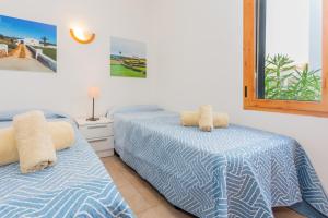 Un dormitorio con dos camas y una ventana. en Apartamento en Arenal en Castell, en Arenal d'en Castell 18 fotos más