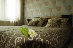 a bedroom with a bed with a flower on it at Guesthouse Viktoria in Peshtera