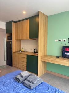 a kitchen with a bed with towels on it at Terpenica in Pattaya