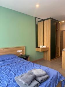 a bedroom with a blue bed with towels on it at Terpenica in Pattaya