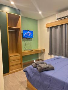 a bedroom with a bed and a tv on a wall at Terpenica in Pattaya