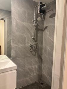 a shower in a bathroom with a gray tiled wall at Terpenica in Pattaya +27 photos