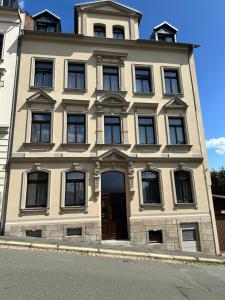 a large yellow building with a door on a street at Home by Ginger in Reichenbach im Vogtland