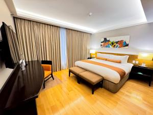 a hotel room with a bed and a chair at The Bellevue Manila in Manila