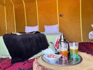 a table with a tray of food and drinks on a bed at Guesthub camp in Merzouga