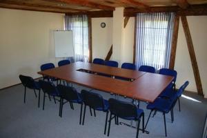 sala konferencyjna z dużym drewnianym stołem i krzesłami w obiekcie Klumpes Malunas w mieście Vosbutai