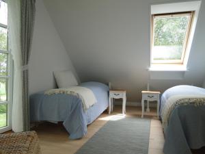 a bedroom with two twin beds and a window at Dyssegaard Holiday Apartment in Skallerup