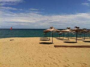 a group of umbrellas on a beach with the ocean at Hostel Rayska Yabalka in Varna City