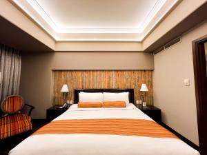 a hotel room with a bed and a chair at The Bellevue Manila in Manila