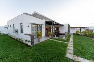 a white house with a green yard at Mauritius in Midlands Station