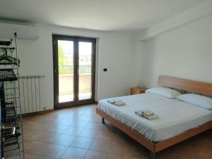 a bedroom with a bed and a balcony at Villa Toti in Montepaone
