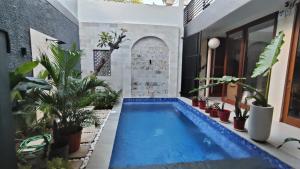 a swimming pool in a house with plants at Biring Homestay in Sanur +2 photos
