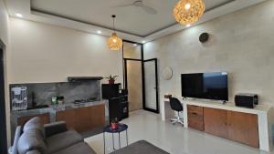 a living room with a couch and a flat screen tv at Biring Homestay in Sanur