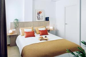 una camera da letto con un letto grande con cuscini arancioni di REM II Torrevieja a Torrevieja