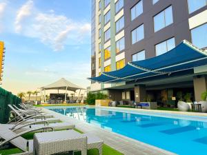 a swimming pool with chairs and a hotel at The Bellevue Manila in Manila