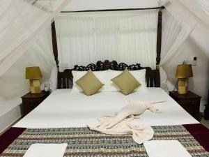 a bedroom with a bed with a woman laying on it at El Corazon De Hikkaduwa in Hikkaduwa