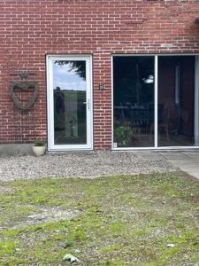 a brick building with a door and a window at Højmosegård HEMS in Varde