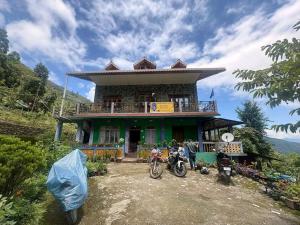 a house with two motorcycles parked in front of it at Khimdung Mannat Homestay in Mangpu