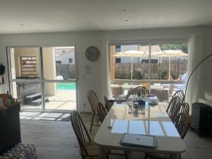 a dining room with a table with a laptop on it at 4 bedroom 4 bathroom villa 15 with pool and hot tub in Saint-Augustin