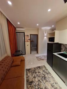 un salon avec un canapé et une cuisine dans l'établissement NBG beach panorama apartment batumi, à Batoumi