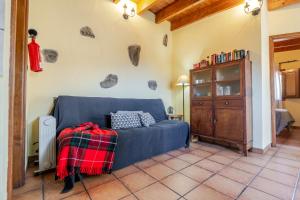 ein Wohnzimmer mit einem blauen Sofa und einem Schrank in der Unterkunft Casita Feliz - Casa Rural Tasarte by Villas Rivero in Tasarte