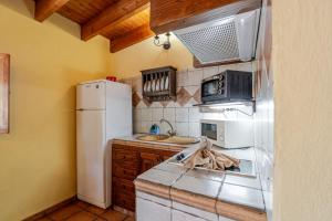 eine Küche mit einem weißen Kühlschrank und einer Spüle in der Unterkunft Casita Feliz - Casa Rural Tasarte by Villas Rivero in Tasarte