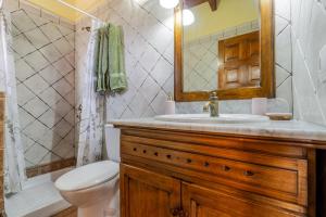 ein Badezimmer mit Waschbecken, Toilette und Spiegel in der Unterkunft Casita Feliz - Casa Rural Tasarte by Villas Rivero in Tasarte
