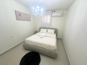 a bedroom with a bed and a chandelier at בית יפה-casa Bella in Qiryat Shemona