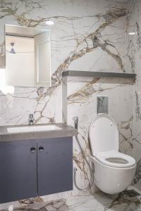 Un baño con un inodoro blanco y un lavabo. en Cozmo Studio, Next to Pune Airport, en Pune
