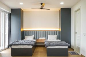 Dos camas en una habitación con paredes azules. en Cozmo Studio, Next to Pune Airport, en Pune