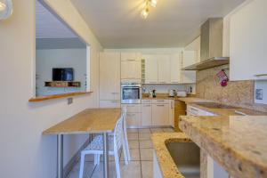 a kitchen with white cabinets and a table and chairs at Le Gîte La Pierre Pons - vue montagne in Voglans