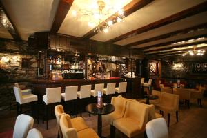 a restaurant with a bar with white chairs and tables at Patriko Mountain Chalet in Palaios Agios Athanasios