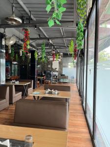 a restaurant with tables and plants hanging from the ceiling at Aanandam Hotel in Babarpur