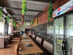 a restaurant with tables and chairs and a wall with plants at Aanandam Hotel in Babarpur +18 photos