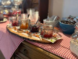 a wooden tray with jars of jam on a table at Pension Schihütte in Oberstaufen